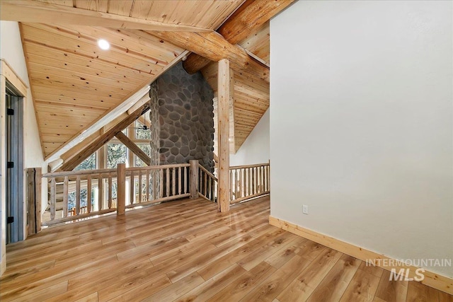 additional living space featuring vaulted ceiling with beams, light hardwood / wood-style flooring, and wood ceiling