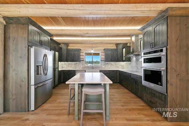 kitchen featuring appliances with stainless steel finishes, light hardwood / wood-style floors, a kitchen island, and range hood