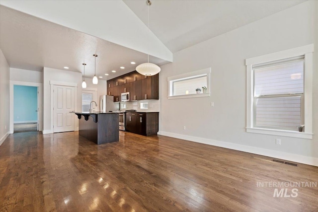 924 E Wright St, Boise, ID 83706 - kitchen featuring a breakfast bar area, a center island with sink, dark brown cabinets, stainless steel appliances, and dark wood-style floors