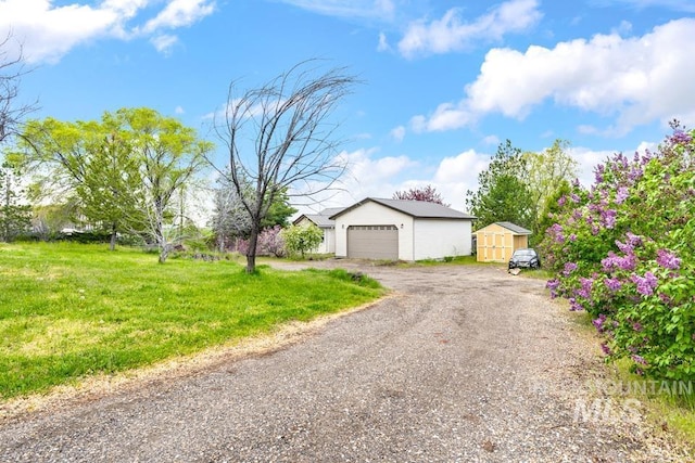 view of front of property featuring a garage, a shed, and a front yard