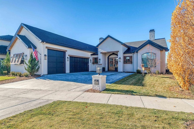 view of front of home with a garage and a front lawn