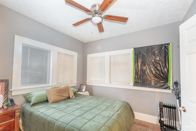 bedroom featuring a textured ceiling, ceiling fan, baseboards, and radiator