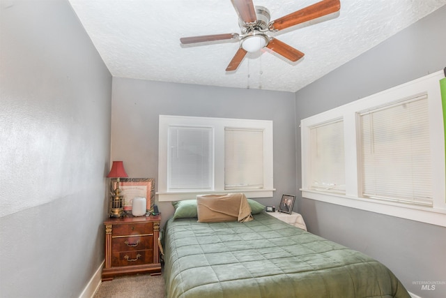 bedroom with carpet, baseboards, ceiling fan, and a textured ceiling