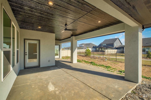 view of patio featuring a ceiling fan, fence, and a residential view