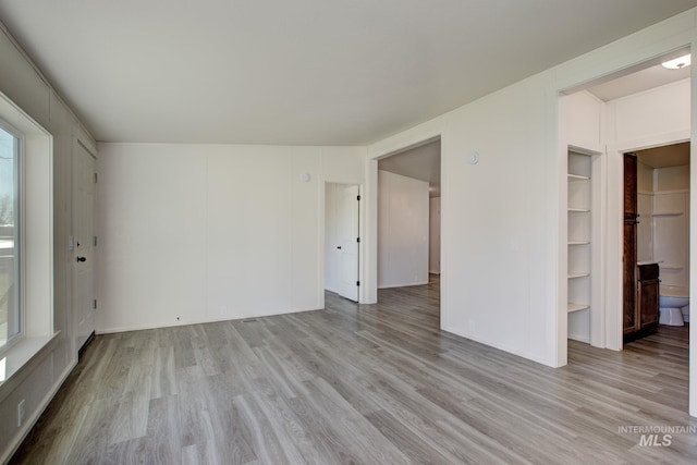 empty room with light wood-type flooring and built in features