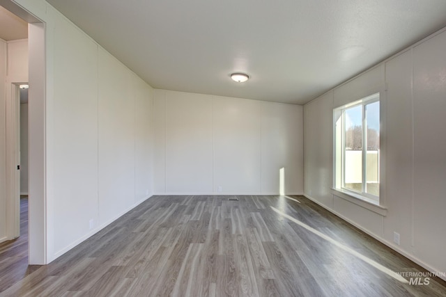 unfurnished room with hardwood / wood-style flooring