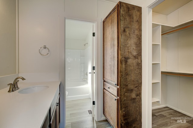 bathroom featuring hardwood / wood-style floors, vanity, and shower / tub combination