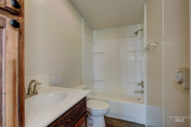 full bathroom with hardwood / wood-style floors, vanity, bathing tub / shower combination, and toilet