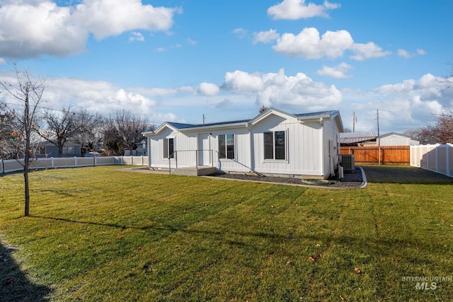 rear view of property with a lawn and central AC