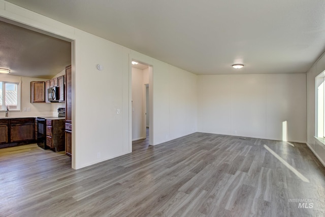 unfurnished living room with sink and light hardwood / wood-style flooring