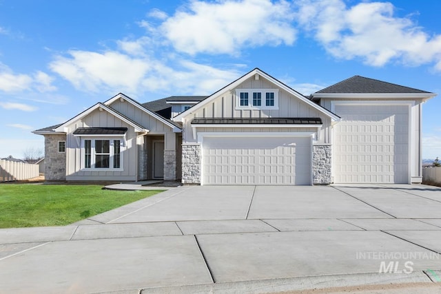 2716 N Heirloom Ave, Eagle, ID 83616 - view of front facade with board and batten siding, stone siding, a front lawn, an attached garage, and concrete driveway