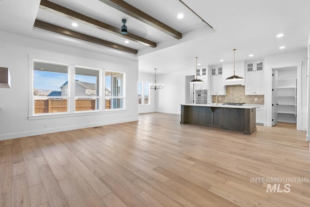 2716 N Heirloom Ave, Eagle, ID 83616 - kitchen featuring light wood-style flooring, backsplash, light countertops, and white cabinetry