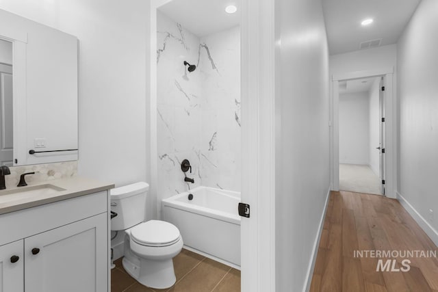 2716 N Heirloom Ave, Eagle, ID 83616 - bathroom featuring visible vents, toilet, vanity, wood finished floors, and shower / bath combination