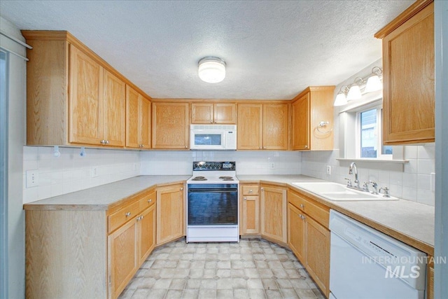 kitchen featuring decorative backsplash, light brown cabinetry, white appliances, and sink