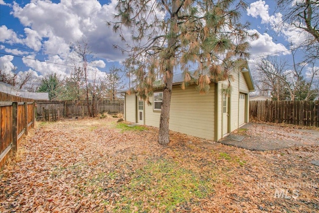 view of side of home featuring an outbuilding and a garage