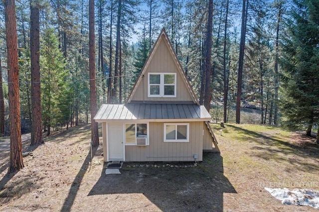 exterior space with metal roof and a forest view
