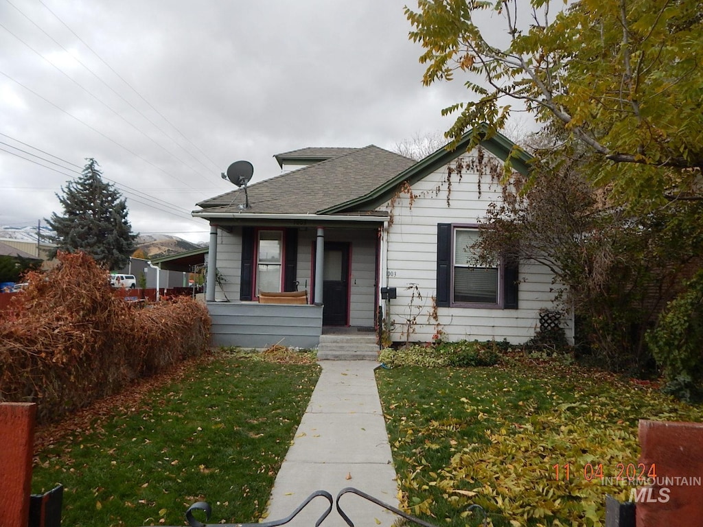 bungalow-style house featuring a front lawn