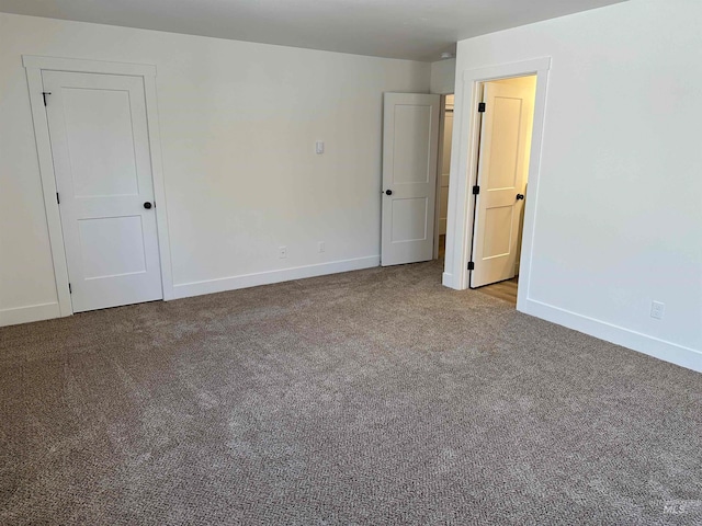 unfurnished room with carpet and baseboards