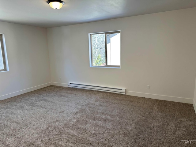 carpeted empty room with a baseboard heating unit and baseboards