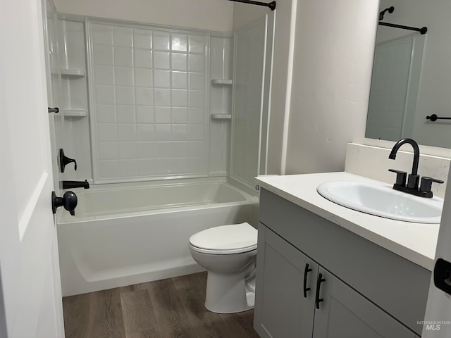 bathroom featuring vanity, tub / shower combination, wood finished floors, and toilet