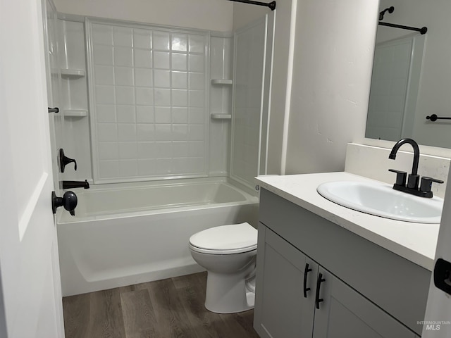 bathroom with washtub / shower combination, vanity, toilet, and wood finished floors