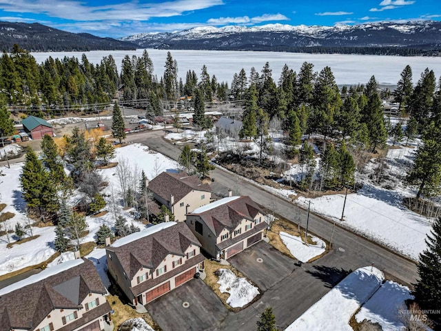 snowy aerial view with a residential view and a mountain view