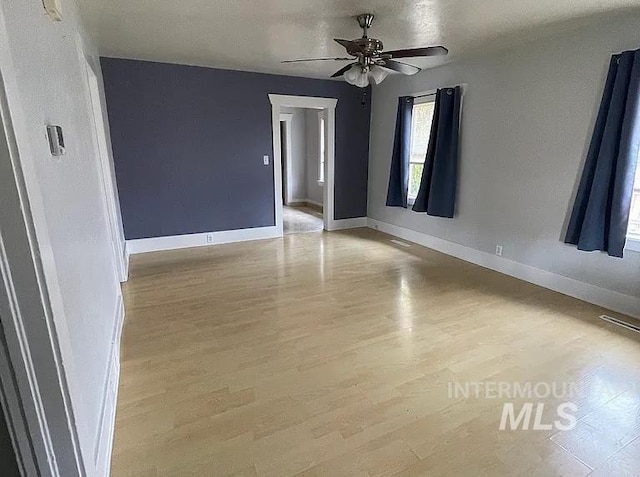 empty room featuring ceiling fan and light hardwood / wood-style flooring