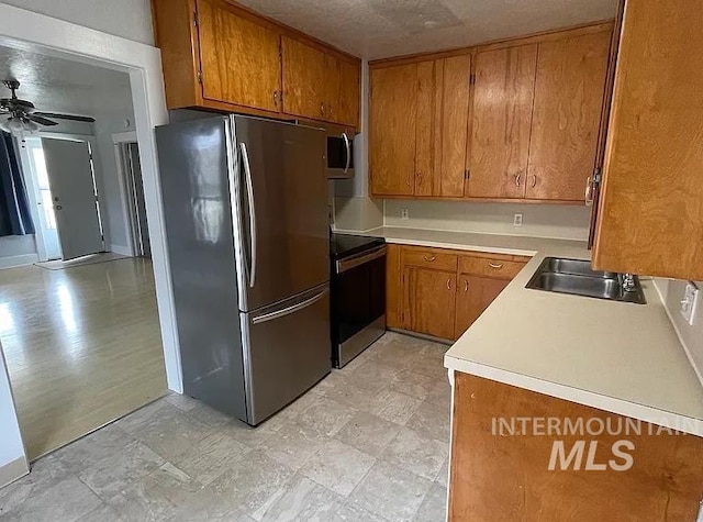 kitchen with appliances with stainless steel finishes, sink, and ceiling fan