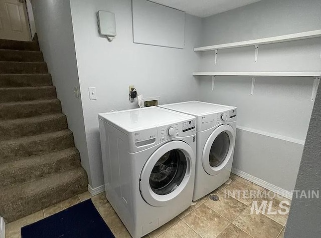 laundry area with separate washer and dryer and light tile patterned floors