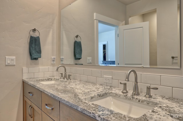 bathroom featuring vanity and decorative backsplash