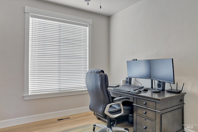 home office featuring ceiling fan and light hardwood / wood-style floors