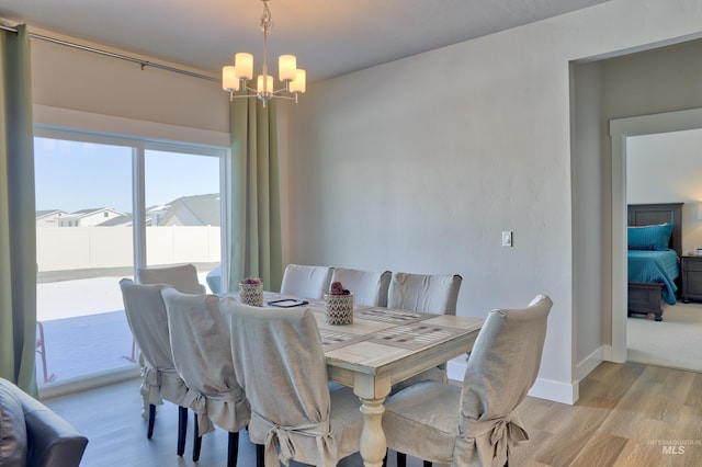 dining space with a notable chandelier and light hardwood / wood-style flooring