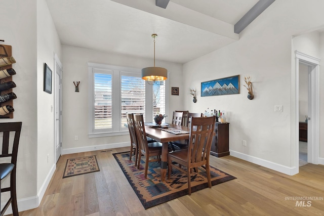 dining area with light wood-style flooring, baseboards, and a chandelier