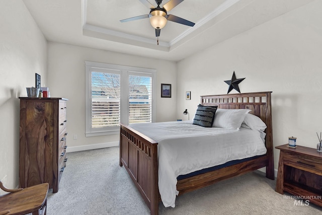 bedroom with light carpet, baseboards, a tray ceiling, and ornamental molding