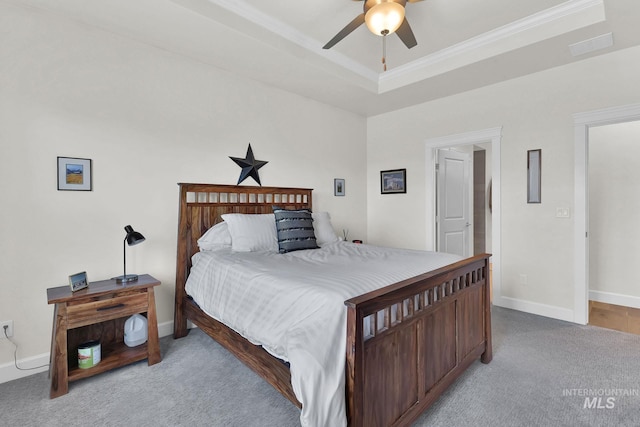 bedroom with carpet, a raised ceiling, and baseboards