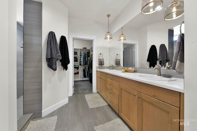 bathroom featuring a sink, a spacious closet, and double vanity