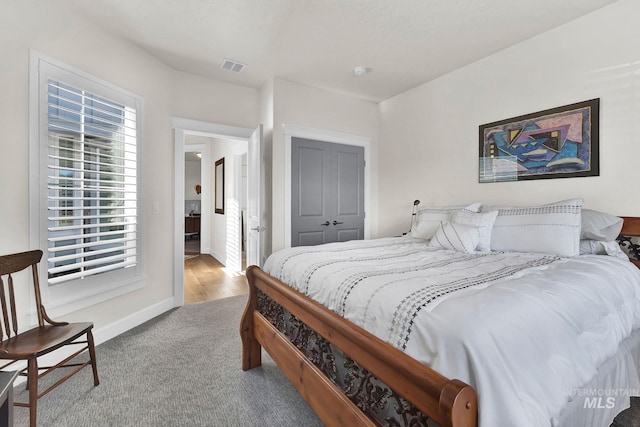 bedroom featuring a closet, baseboards, visible vents, and carpet flooring