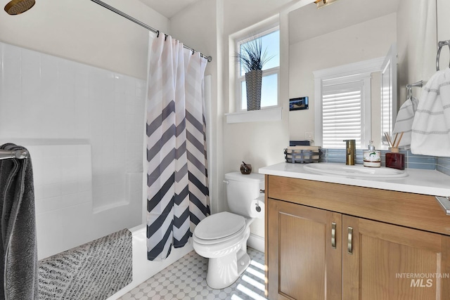 bathroom featuring toilet, vanity, and a shower with shower curtain