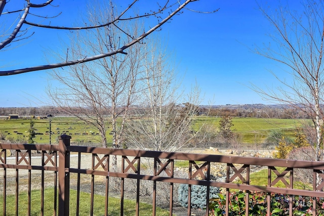 exterior space with fence and a rural view