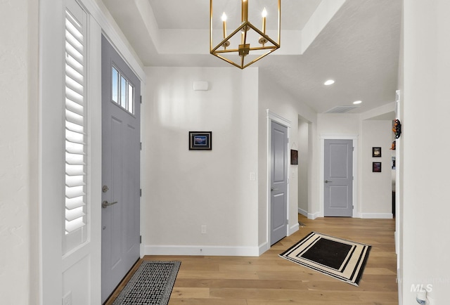 entrance foyer featuring a notable chandelier, recessed lighting, light wood-style flooring, and baseboards