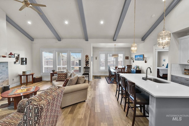 living area with ceiling fan, recessed lighting, a fireplace, baseboards, and light wood-style floors