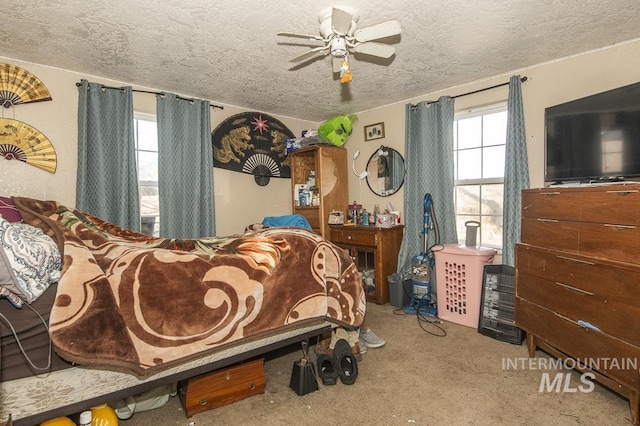 bedroom with multiple windows, a textured ceiling, and ceiling fan