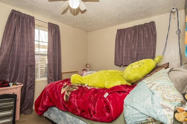 carpeted bedroom with ceiling fan and a textured ceiling