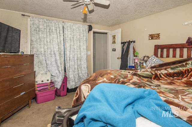 carpeted bedroom featuring ceiling fan and a textured ceiling