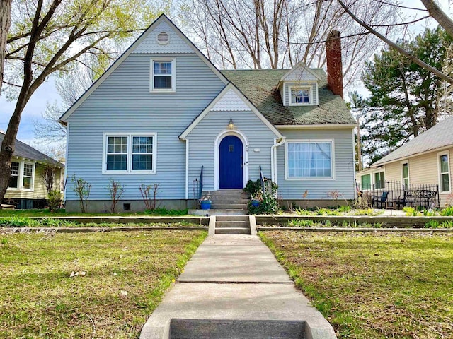 view of front of home featuring a front lawn and a chimney