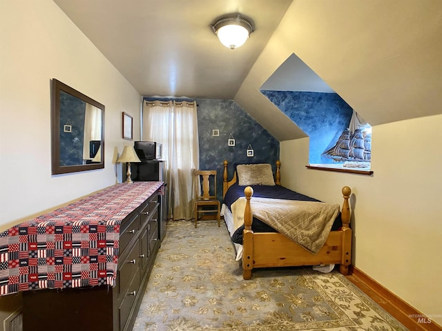 bedroom with baseboards and lofted ceiling