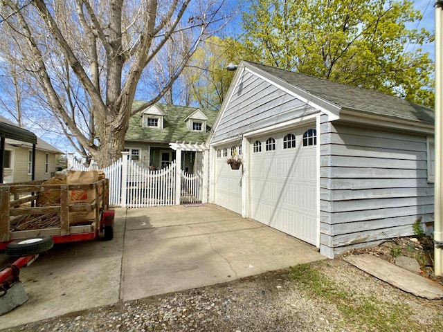 detached garage with a gate and fence