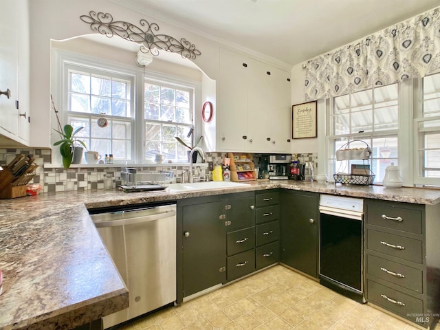 kitchen with tasteful backsplash, stainless steel dishwasher, a sink, ornamental molding, and white cabinetry
