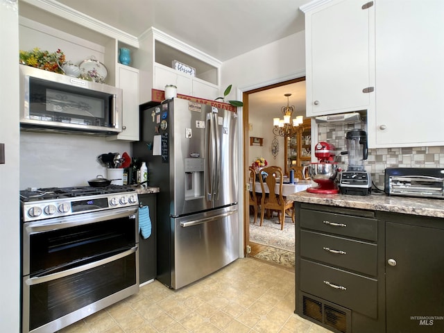 kitchen with white cabinetry, appliances with stainless steel finishes, an inviting chandelier, and a toaster