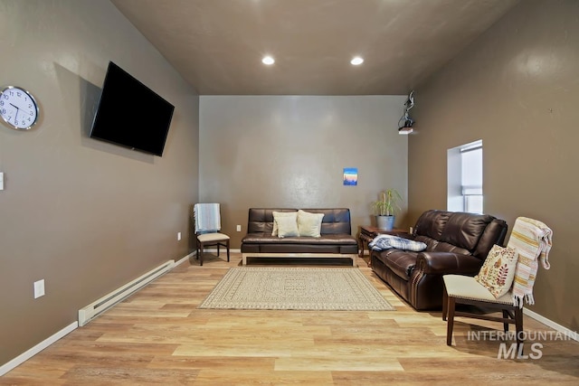 living room featuring a baseboard heating unit and light wood-type flooring